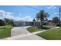 Inviting single-story home with a well manicured lawn, complemented by a mature palm tree at 6360 Jordan St, North Port, FL 34287