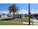 Well-maintained single-story home featuring a mature palm tree and manicured front lawn at 6360 Jordan St, North Port, FL 34287