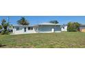 Back of house featuring a spacious yard, a gas propane tank, and new windows at 6360 Jordan St, North Port, FL 34287