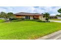Well-maintained front yard with lush green grass, mature trees, and neatly trimmed shrubs at 8402 13Th Nw Ave, Bradenton, FL 34209
