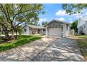 Exterior of a home with an attached garage and a long driveway in a suburban neighborhood at 8413 Lincolnshire Dr, Hudson, FL 34667