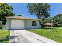 Front view of the house with a concrete driveway, attached garage, and neatly manicured lawn at 8730 Filson Pl, Sarasota, FL 34231
