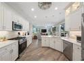 Modern kitchen with white cabinets, stainless steel appliances, and wood-look flooring, open to the living area at 9635 Discovery Ter, Bradenton, FL 34212