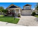 Beautiful two-story home with a well-manicured lawn, complemented by stone accents and a paved driveway leading to the garage at 11411 Spring Gate Trl, Bradenton, FL 34211
