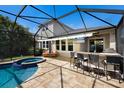 Outdoor entertaining area with covered bar, television, seating, and a view of the in-ground pool and spa at 11411 Spring Gate Trl, Bradenton, FL 34211