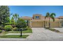 Charming home featuring a tile roof, two-car garage, brick paver driveway and lush green landscaping at 11603 Bluebird Pl, Lakewood Ranch, FL 34211