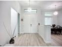 Bright foyer with high ceilings, wood-look floors, and an eye-catching light fixture at 11960 De Leon Dr, North Port, FL 34287