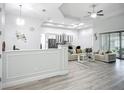 A spacious and bright living room with a white couch, recessed lighting, and gray wood-look floors at 11960 De Leon Dr, North Port, FL 34287