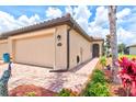Exterior shot of the house highlighting the brick walkway and landscaping at 12230 Amica Loop, Venice, FL 34293