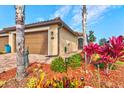 Charming single-story home featuring a terracotta roof, paver driveway, two car garage and beautifully landscaped front yard at 12230 Amica Loop, Venice, FL 34293