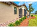 Charming home featuring a screened in lanai, stucco exterior, and beautifully landscaped yard with a brick paver walkway at 12230 Amica Loop, Venice, FL 34293