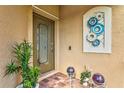 Charming front entrance with a decorative glass door, brick flooring, and beautiful decorations at 12230 Amica Loop, Venice, FL 34293