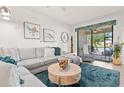 Inviting living room with a comfortable sectional sofa, stylish decor, and access to the outdoor patio at 12230 Amica Loop, Venice, FL 34293