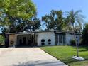 Single-story home with a well-kept lawn, mature landscaping, and a convenient carport at 1801 Marilyn Ave, Bradenton, FL 34207