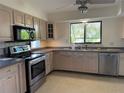 Bright kitchen with stainless steel appliances, light wood cabinets and a sunlit window at 191 Maria Ct, Punta Gorda, FL 33950