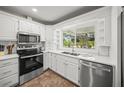White kitchen with stainless steel appliances, a double basin sink, and tiled backsplash at 1915 38Th W St, Bradenton, FL 34205