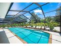Covered pool with brick coping, screened in lanai, and professionally landscaped surrounding the pool at 1915 38Th W St, Bradenton, FL 34205