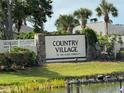Country Village 55 and older community entrance sign surrounded by lush landscaping and palm trees at 2841 74Th St W # 2841, Bradenton, FL 34209