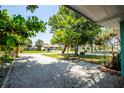 Charming home with pea gravel driveway, mature trees and lush, green landscaping at 302 Pavonia Rd, Nokomis, FL 34275