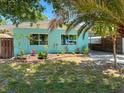 Cozy turquoise home with well-manicured landscaping including small plants, grass, and a carport at 302 Pavonia Rd, Nokomis, FL 34275