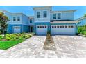 Charming blue townhome with a two-car garage and beautiful landscaping in front at 305 Via Tuscany Ave, Sarasota, FL 34243