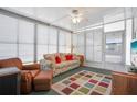 Bright sunroom with comfortable seating, fan, and lots of light from the many white-shuttered windows at 3214 Sycamore Ter, Sarasota, FL 34237