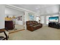 Comfortable living room featuring neutral carpeting, a ceiling fan, and a comfortable leather sofa at 3214 Sycamore Ter, Sarasota, FL 34237