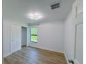 Bright bedroom with wood-look flooring, a modern ceiling fan, and a window offering natural light at 3386 Irma St, North Port, FL 34291