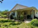 Side view of the home showing landscaping, covered porch, neutral color scheme, and window frames at 3828 6Th W Ave, Palmetto, FL 34221