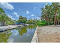 Scenic view of the backyard and canal, enhanced by vibrant greenery and ample space for outdoor enjoyment at 385 Avenida Madera, Sarasota, FL 34242