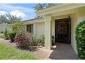 Front entrance features a decorative security door and mature landscaping around the walkway at 4109 Carriage Dr # 23, Sarasota, FL 34241