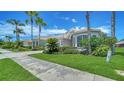 Single-Gathering home with manicured front yard, tropical plants and lush green grass along the sidewalk at 4220 Miriana Way, Sarasota, FL 34233