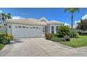 Well-maintained house with a two-car garage, nicely manicured lawn and tropical plants in front of the house at 4220 Miriana Way, Sarasota, FL 34233