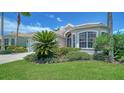 Beautifully landscaped front yard with lush green grass, shrubs and well-maintained exterior of the house at 4220 Miriana Way, Sarasota, FL 34233
