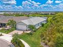 Aerial view of a landscaped home with a lake view, featuring a paved driveway and two-car garage at 42250 Ramble Rd, Punta Gorda, FL 33982