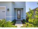 A welcoming walkway leads to the front door, framed by lush greenery and blooming plants at 4524 Pippin Ln, Lakewood Ranch, FL 34211