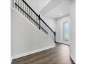 Elegant staircase with dark wood floors and a sleek black railing leading upstairs at 4524 Pippin Ln, Lakewood Ranch, FL 34211