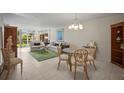 Bright living room features neutral decor, comfortable seating, tile flooring, and a dining area near sliding glass doors at 4530 Pinebrook Cir # 109, Bradenton, FL 34209