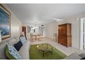 Inviting living room features a glass coffee table, comfortable sofa, and view to the dining area at 4530 Pinebrook Cir # 109, Bradenton, FL 34209