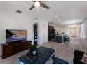 Bright living room with sleek tile flooring, a ceiling fan, and a view leading to a modern kitchen at 4739 Reisswood Loop, Palmetto, FL 34221
