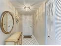 Inviting foyer with a white tile floor, mirror and coat closet at 6108 7Th W Ave # 6108, Bradenton, FL 34209
