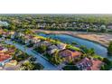 This aerial view captures a home on a golf course with a lake, surrounded by lush trees and manicured lawns at 6914 Dominion Ln, Lakewood Ranch, FL 34202