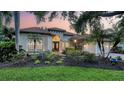 Stunning single-story home featuring a barrel tile roof, lush landscaping, and a grand double-door entrance at 6914 Dominion Ln, Lakewood Ranch, FL 34202