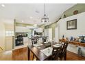 Dining room and kitchen featuring hardwood floors, modern lighting, and neutral paint at 7532 Marsh Orchid Cir # 8-201, Bradenton, FL 34203