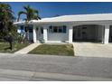 Inviting single-story home with a bright exterior, white tile roof, and convenient carport at 754 Spanish S Dr # 754, Longboat Key, FL 34228