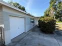 Side view of home featuring an attached garage, well-maintained lawn and shrubbery at 8291 57Th N St, Pinellas Park, FL 33781