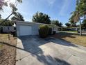 Home featuring an attached garage, well-maintained lawn and manicured shrubbery at 8291 57Th N St, Pinellas Park, FL 33781