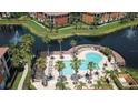 Aerial view showcasing the community pool, lake, and manicured grounds creating a tranquil oasis at 8341 38Th Street Cir E # 303, Sarasota, FL 34243