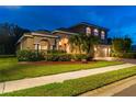Attractive two-story house boasts a brick driveway, three car garage, and landscaped front yard at 9008 Brookfield Ter, Bradenton, FL 34212