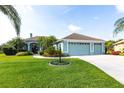 Charming one-story home boasts a lush green lawn, mature palm trees, and a three-car garage at 9017 Province St, Sarasota, FL 34240
